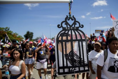 Los manifestantes portan una imagen del gobernador Ricardo Rosselló como un ave enjaulada durante una protesta para exigir su renuncia al cargo.