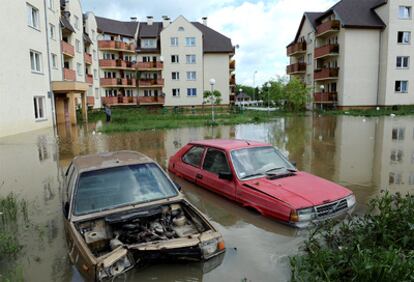 Dos coches abandonados aparecen casi sumergidos en una zona inundada en el distrito Kozanov en Wroclaw.