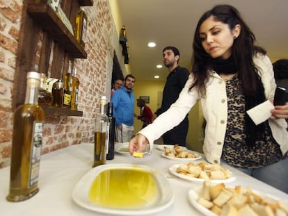 Una mujer prueba aceite de oliva con pan durante su visita a la primera Oleoteca Internacional dedicada al aceite de oliva virgen, en Santa Cruz del Valle (&Aacute;vila) 