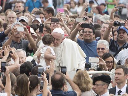 El papa Francisco besa a un niño durante su tradicional audiencia general celebrada en la Plaza de San Pedro del Vaticano, en la Ciudad del Vaticano.  
 
 