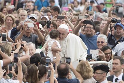 El papa Francisco besa a un niño durante su tradicional audiencia general celebrada en la Plaza de San Pedro del Vaticano, en la Ciudad del Vaticano.  
 
 