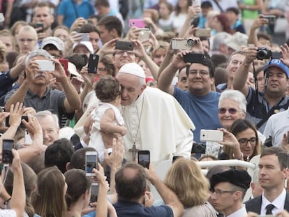 El papa Francisco besa a un niño durante su tradicional audiencia general celebrada en la Plaza de San Pedro del Vaticano, en la Ciudad del Vaticano.  
 
 