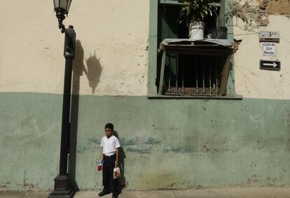 Un estudiante sostiene una bandera panameña y su almuerzo antes de un desfile del día de la independencia en ciudad de Panamá.