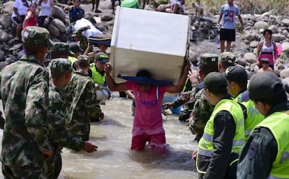 Un colombiano carga con un frigorífico en el cruce de la frontera.