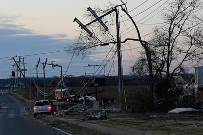 A vehicle sits by the side of the road near damaged power lines on Sunday, Dec. 10, 2023, Clarksville, Tenn. Central Tennessee residents and emergency workers are continuing the cleanup from severe weekend storms.