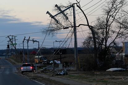 A vehicle sits by the side of the road near damaged power lines on Sunday, Dec. 10, 2023, Clarksville, Tenn. Central Tennessee residents and emergency workers are continuing the cleanup from severe weekend storms.