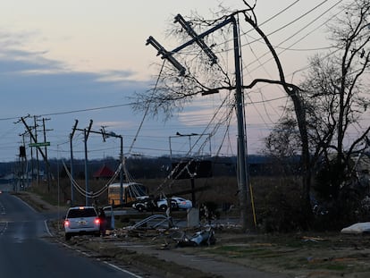 A vehicle sits by the side of the road near damaged power lines on Sunday, Dec. 10, 2023, Clarksville, Tenn. Central Tennessee residents and emergency workers are continuing the cleanup from severe weekend storms.