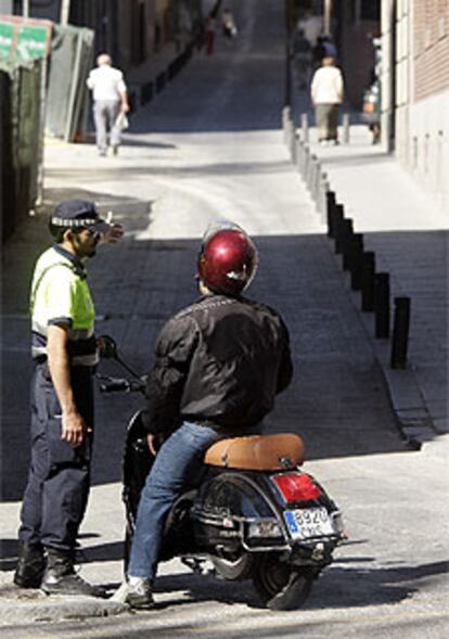 Un motorista recibe las explicaciones de un agente municipal sobre el corte de tráfico en la zona de Huertas.