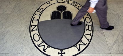 Un hombre caminando sobre un logo tipo de Monte Dei Paschi Di Siena Bank en Roma.