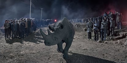 Um rinoceronte fotografado no ambiente onde uma construção era feita. As imagens dos humanos, dos animais e da construção foram registradas no mesmo local, porém, em momentos diferentes, e depois sobrepostas para formar o cenário.