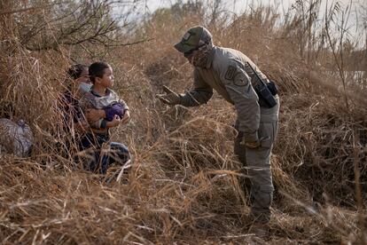 Un policía texano conversa con una solicitante de asilo hondureña y su hijo de 4 años después de que estos cruzaran el Río Bravo el 9 de marzo en Peñitas, en el Valle del Río Grande.