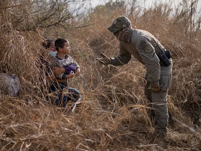 Un policía texano conversa con una solicitante de asilo hondureña y su hijo de 4 años después de que estos cruzaran el Río Bravo el 9 de marzo en Peñitas, en el Valle del Río Grande.