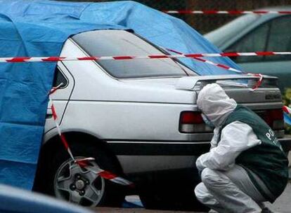 Un agente de policía francés examina el coche en el que fueron asesinados dos guardias civiles en Capbreton.