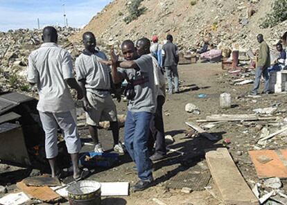 Un grupo de inmigrantes subsaharianos, en la escombrera de Loma Larga, en Ceuta, donde pasan el día.