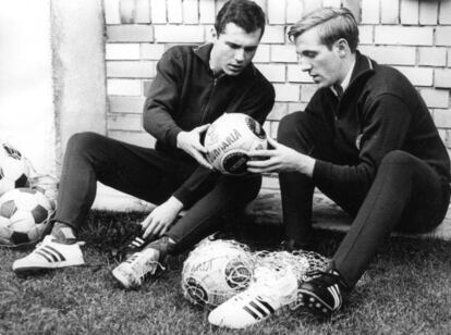 Beckembauer y Günter Netzer examinan el nuevo balón reglamentario en 1964. (Getty)