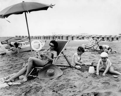 woman reading a book under the beach umbrella