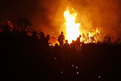 Un grupo de bomberos intenta controlar las llamas del llamado "Springs Fire" (fuego de primavera) en las monta?as de Potrero Road, California. El incendio ha comenzado a remitir gracias a la menor intensidad del viento y la bajada de las temperaturas.