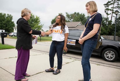 Sparks saluda a Lynn Paratt, residente del distrito 12 mientras hace campaña con la comisionada Emily Bridson (derecha), en Kentwood.