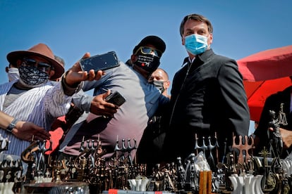 Jair Bolsonaro posa com apoiadores em frente à Catedral de Brasília, em 23 de agosto.