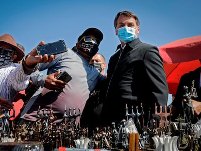 Jair Bolsonaro posa com apoiadores em frente à Catedral de Brasília, em 23 de agosto.