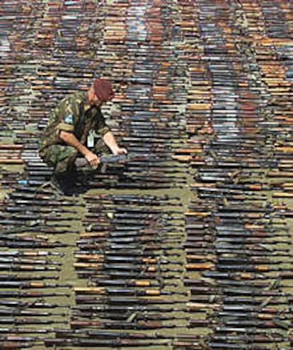 Un soldado de la OTAN cuenta los fusiles de asalto AK-47.