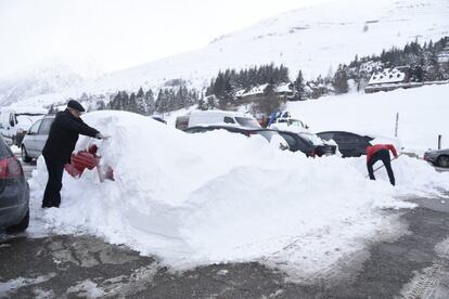 Un home treu la neu d'un cotxe a Vaquèira Beret (Vall d'Aran).