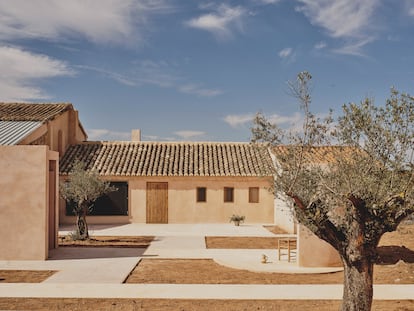 A la vivienda se accede a través de un recorrido marcado por suelo de hormigón, tierra y olivos.