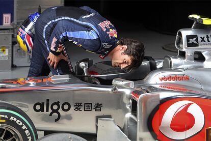 Mark Webber echa un vistazo al interior del <i>cockpit</i> de Lewis Hamilton tras concluir la prueba de clasificación