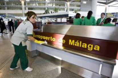 Una trabajadora limpia un punto de información de la terminal T-3 del aeropuerto de Málaga. EFE/Archivo