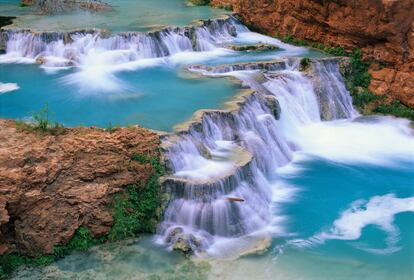 En Havasu Canyon, un angosto ramal del Gran Cañón, los havasupai, el "pueblo del agua azul", cultivan la tierra desde hace al menos 700 años. Los havasupai reciben su nombre por el color turquesa de las pozas y cascadas --Navajo Falls, Beaver Falls, Havasu Falls y Mooney Falls-- que forman varios torrentes subsidiarios del río Colorado. La cascada de Mooney es la más visitada, y lleva el nombre de un desdichado minero que cayó en ella y se ahogó. En la de Beaver (en la foto) el agua forma bellas pozas azules sobre terrazas de travertino.