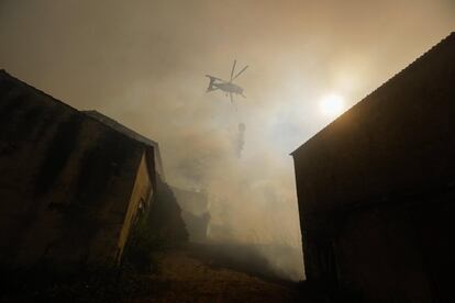 Un helicptero arroja agua sobre un incendio forestal en la Villa Pisao, en Mealhada (Portugal). Mas de 319 bomberos, 94 vehculos terrestres y seis helicpteros y aviones luchan por sofocar el incendio forestal.