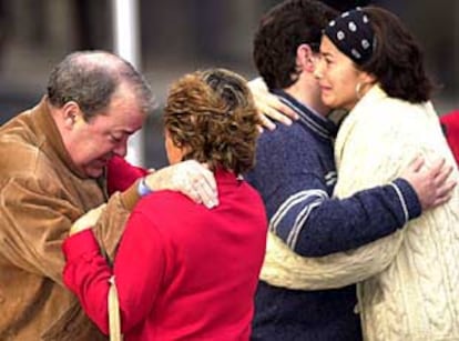 El cuñado y otros familiares del magistrado asesinado se abrazan tras conocer la noticia.