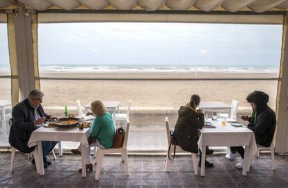 Clientes en la terraza de un bar de Valencia, este lunes. La hostelería de la Comunidad Valenciana ha recuperado a su clientela en las terrazas en la reapertura de sus establecimientos tras 40 días de cierre. Pese a las restricciones de un 75% de limitación de aforo, horario de apertura hasta las 18:00 horas y un máximo de cuatro personas por mesa, los hosteleros han asegurado que el poder abrir les permite tener un desahogo para poder recuperar parte de lo perdido en estos meses.