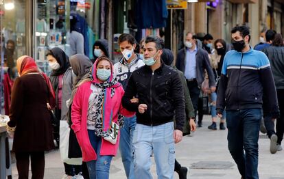 Viandantes con mascarillas en una calle de Teherán.