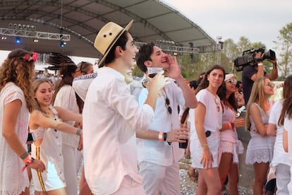 Asistentes al festival ven desde la pista de baile a los organizadores hablando en el escenario