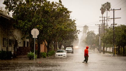 A man crosses a flooded street during an atmospheric river weather event in Santa Barbara, California USA, 04 February 2024.