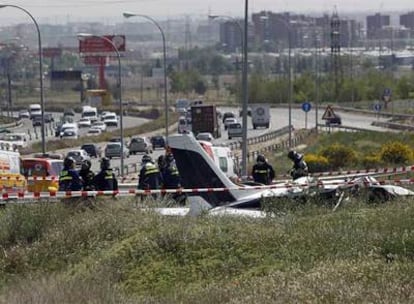 Los bomberos del Ayuntamiento de Madrid inspeccionan la avioneta siniestrada junto a la autovía M-40.