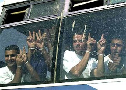 Un grupo de palestinos puestos en libertad por Israel hace señales de victoria desde el autobús en que es trasladado.