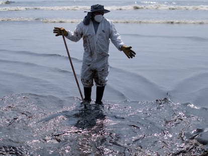 Un trabajador en las tareas de limpia en la playa de Ventanilla, en Perú, este martes 18 de enero.