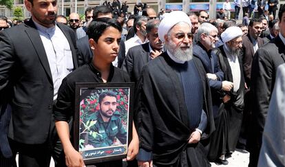 El presidente de Ir&aacute;n, Hasan Rohan&iacute;, camina el pasado viernes junto a los familiares de una de las v&iacute;ctimas del doble atentado de Teher&aacute;n durante los funerales. 