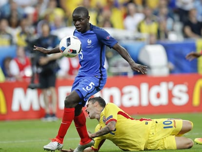 Kant&eacute;, con Stanciu en el suelo, se marcha con el bal&oacute;n en el Francia-Rumania que inaugur&oacute; la Eurocopa 2016.