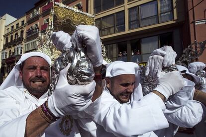 Varios hombres de tronos de 'María Santísima del Rocío', de la Cofradía del Rocío, giran mostrando la virgen al público en la Tribuna de los Pobres, el martes 11 de abril de 2017.