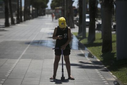 Un joven baja del patinete para mirar el móvil en medio de la calle.