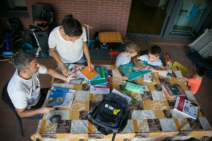 Karima y su marido, Dani, revisan el material escolar de sus tres hijos para el nuevo curso en su casa del barrio madrileño de Villaverde.