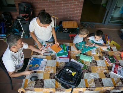 Karima y su marido, Dani, revisan el material escolar de sus tres hijos para el nuevo curso en su casa del barrio madrileño de Villaverde.