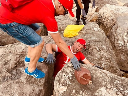 Voluntarios de Coca-Cola limpian la playa de Terramar en Sitges, Barcelona.