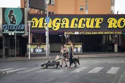 Una família passeja al matí pel carrer de bars de Magaluf.