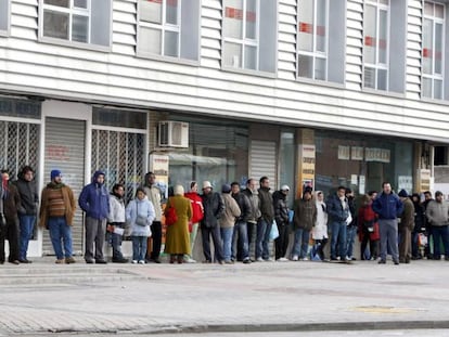 Spaniards wait in line outside a job center.