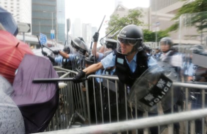 Los antidisturbios golpean a los manifestantes que se acercan a la valla que protege el Consejo Legislativo en Hong Kong. El domingo, la policía ya había empleado la fuerza para disolver los coletazos de la manifestación de un millón de personas según los organizadores (240.000 según la Policía) que ocupó el centro de la ciudad para protestar contra la ley de extradición.