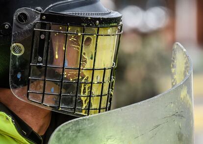 Un disparo de pintura impacta en el casco de un policía durante una manifestación de estudiantes universitarios en Bogotá (Colombia).